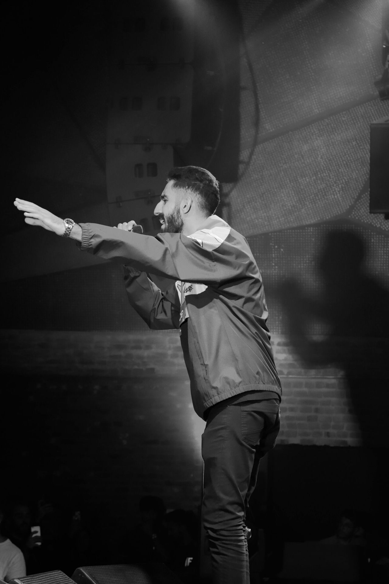 A standup comedian performs for a live audience